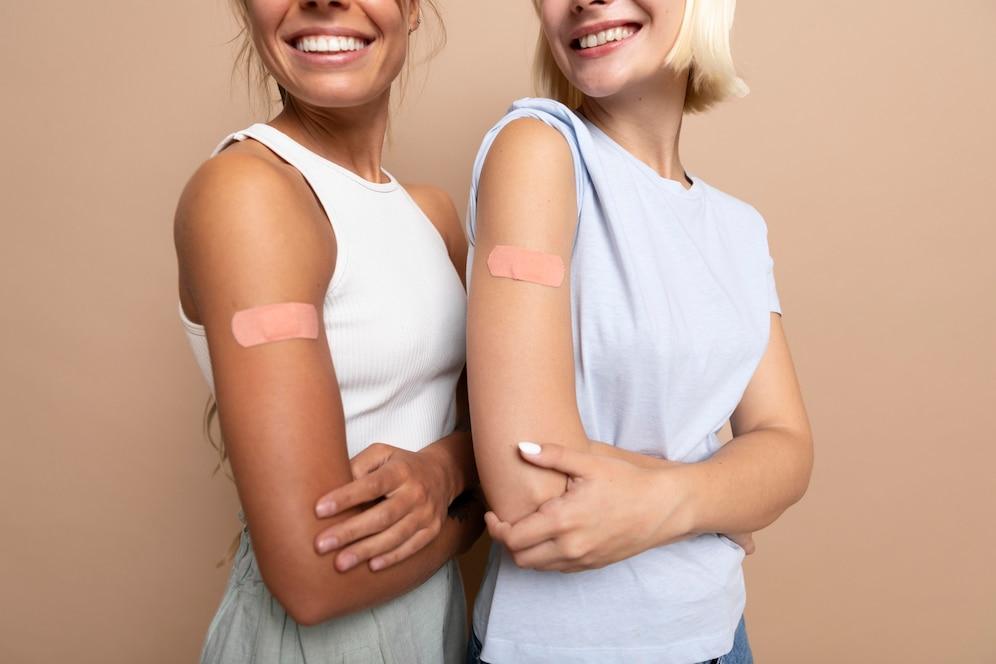 2 meiden met pleister van vaccinatie