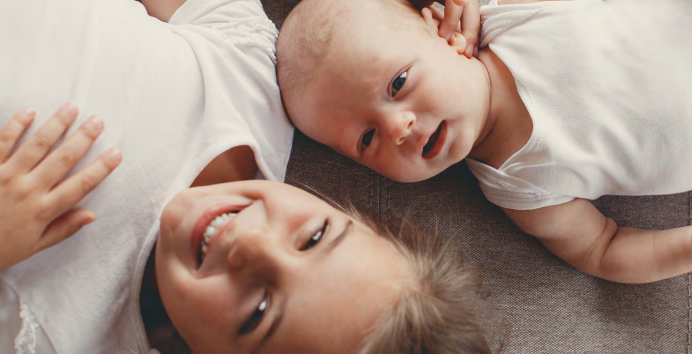 zusje en baby op bed