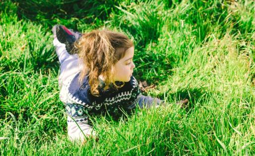 kind in gras spelen